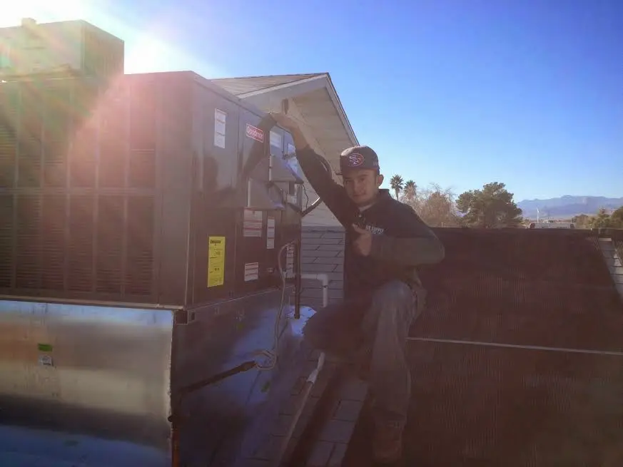 HVAC technician performing HVAC Inspection on a rooftop unit in Sunset